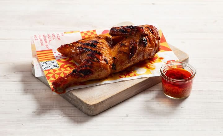Oporto Chicken on an wooden plate served with sauce